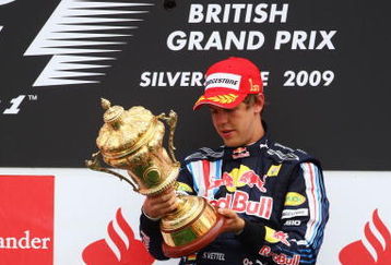 NORTHAMPTON, UNITED KINGDOM - JUNE 21:  Sebastian Vettel of Germany and Red Bull Racing celebrates on the podium after winning the British Formula One Grand Prix at Silverstone on June 21, 2009 in Northampton, England.  (Photo by Paul Gilham/Getty Images)