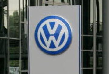 WOLFSBURG, GERMANY - JUNE 27: People holding umbrellas stand in front of a Volkswagen sign during the VFL Wolfsburg training session on June 27, 2007 in Wolfsburg, Germany.  (Photo by Martin Rose/Getty Images)