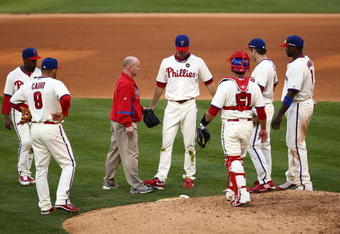 PHILADELPHIA - OCTOBER 08:  Pitcher J.A. Happ (C) #43 of the Philadelphia Phillies is tended to by head athletic trainer Scott Sheridan (L of Happ) after Happ had a ball hit off of his leg in the top of the seventh inning against the Colorado Rockies in Game Two of the NLDS during the 2009 MLB Playoffs at Citizens Bank Park on October 8, 2009 in Philadelphia, Pennsylvania.  (Photo by Chris McGrath/Getty Images)