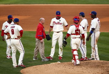 PHILADELPHIA - OCTOBER 08:  Pitcher J.A. Happ (C) #43 of the Philadelphia Phillies is tended to by head athletic trainer Scott Sheridan (L of Happ) after Happ had a ball hit off of his leg in the top of the seventh inning against the Colorado Rockies in Game Two of the NLDS during the 2009 MLB Playoffs at Citizens Bank Park on October 8, 2009 in Philadelphia, Pennsylvania.  (Photo by Chris McGrath/Getty Images)