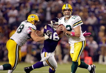MINNEAPOLIS - OCTOBER 05:  Quarterback Aaron Rodgers #12 of the Green Bay Packers is chased by Brian Robinson #96 of the Minnesota Vikings during the Monday Night Football game on October 5, 2009 at Hubert H. Humphrey Metrodome in Minneapolis, Minnesota.  (Photo by Jamie Squire/Getty Images)