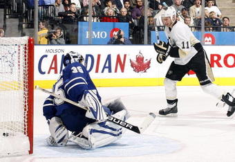 TORONTO - OCTOBER 10:  Vesa Toskala #35 of the Toronto Maple Leafs lets one go through his legs (Shot by Sergei Gonchar) as Jordan Staal #11 of the Pittsburgh Penguins looks on during a NHL game at the Air Canada Centre on October 10, 2009 in Toronto, Ontario, Canada .  (Photo by Abelimages/Getty Images)