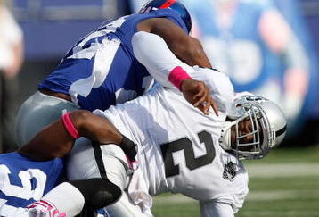 EAST RUTHERFORD, NJ - OCTOBER 11:  JaMarcus Russell #2 of the Oakland Raiders is hit on a play during the game against the New York Giants on October 11, 2009 at Giants Stadium in East Rutherford, New Jersey. (Photo by Jared Wickerham/Getty Images)