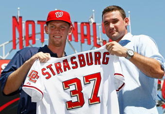 WASHINGTON - AUGUST 21:  Stephen Strasburg (L), the overall first pick in the 2009 MLB Draft, is presented with his jersey by Nationals third baseman Ryan Zimmerman (R) after being introduced at Nationals Park August 21, 2009 in Washington, DC. Strasburg, a right handed pitcher from San Diego State University, signed with the Nationals earlier this week wth a record contract for an amateur player.  (Photo by Win McNamee/Getty Images)