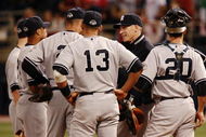 MINNEAPOLIS, MN - OCTOBER 11: Manager Joe Girardi of the New York Yankees speaks with players during a pitching change against the Minnesota Twins in Game Three of the ALDS during the 2009 MLB Playoffs at the Hubert H. Humphrey Metrodome on October 11, 2009 in Minneapolis, Minnesota. (Photo by Genevieve Ross/Getty Images)