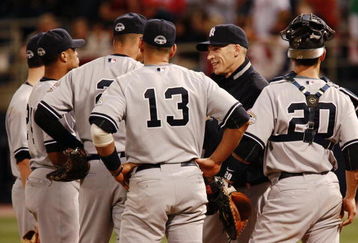 MINNEAPOLIS, MN - OCTOBER 11: Manager Joe Girardi of the New York Yankees speaks with players during a pitching change against the Minnesota Twins in Game Three of the ALDS during the 2009 MLB Playoffs at the Hubert H. Humphrey Metrodome on October 11, 2009 in Minneapolis, Minnesota. (Photo by Genevieve Ross/Getty Images)
