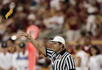 LOS ANGELES - SEPTEMBER 11:  Referee Larry Farina throws a yellow flag during the NCAA game between the University of Southern California Trojans and the Colorado State University Rams at the Los Angeles Memorial Coliseum on September 11, 2004 in Los Angeles, California.  USC won 49-0.  (Photo by Doug Benc/Getty Images)