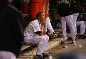 DENVER - OCTOBER 12:  Huston Street #16 of the Colorado Rockies sits dejected in the dugout after the loss against the Philadelphia Phillies in Game Four of the NLDS during the 2009 MLB Playoffs at Coors Field on October 12, 2009 in Denver, Colorado. (Photo by Jed Jacobsohn/Getty Images)