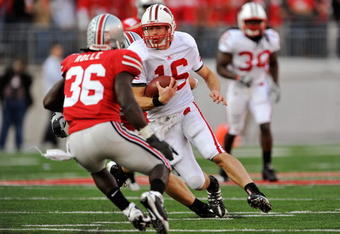 COLUMBUS, OH - OCTOBER 10:  Quarterback Scott Tolzien #16 of the Wisconsin Badgers looks for running room as Brian Rolle #36 of the Ohio State Buckeyes closes in for the tackle at Ohio Stadium on October 10, 2009 in Columbus, Ohio.  (Photo by Jamie Sabau/Getty Images)