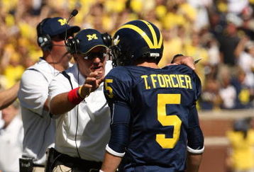 ANN ARBOR, MI - SEPTEMBER 19:  Head coach Rich Rodriguez of the Michigan Wolverines talks with quarterback Tate Forcier #5 during the game with the Eastern Michigan Eagles at Michigan Stadium on September 19, 2009 in Ann Arbor, Michigan.  Michigan won 45-17.  (Photo by Stephen Dunn/Getty Images)