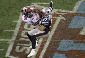 GLENDALE, AZ - FEBRUARY 03:  David Tyree #85 of the New York Giants catches a 32-yard pass from Eli Manning #10 as Rodney Harrison #37 of the New England Patriots attempts to knock it out in the fourth quarter of Super Bowl XLII on February 3, 2008 at the University of Phoenix Stadium in Glendale, Arizona. The Giants defeated the Patriots 17-14.  (Photo by Doug Pensinger/Getty Images)