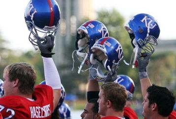 LAWRENCE, KS - SEPTEMBER 22:   Kansas Jayhawk players hoist their helmets as the campus looms in the background prior to the start of the game against the Florida International Golden Panthers on September 22, 2007 at Memorial Stadium in Lawrence, Kansas.  (Photo by Jamie Squire/Getty Images)