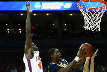 KANSAS CITY, MO - MARCH 19:  Manny Harris #3 of the Michigan Wolverines jumps to the basket for a scoring attempt against Tanner Smith #5 of the Clemson Tigers during the first round of the NCAA Division I Men's Basketball Tournament at the Sprint Center on March 19, 2009 in Kansas City, Missouri.  (Photo by Jamie Squire/Getty Images)