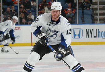 UNIONDALE, NY - APRIL 04: Ryan Malone #12 of the Tampa Bay Lightning moves the puck against the New York Islanders in a National Hockey League game at Nassau Coliseum on April 4, 2009 in Uniondale, New York. (Photo by Paul Bereswill/Getty Images)