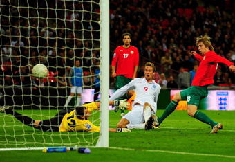 LONDON, ENGLAND - OCTOBER 14:  Peter Crouch (#() of England shoots and scores the third goal of the game during the FIFA 2010 World Cup Qualifying Group 6 match between England and Belarus at Wembley Stadium on October 14, 2009 in London, England.  (Photo by Mike Hewitt/Getty Images)