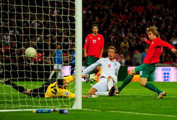 LONDON, ENGLAND - OCTOBER 14:  Peter Crouch (#() of England shoots and scores the third goal of the game during the FIFA 2010 World Cup Qualifying Group 6 match between England and Belarus at Wembley Stadium on October 14, 2009 in London, England.  (Photo by Mike Hewitt/Getty Images)