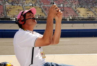 FONTANA, CA - OCTOBER 10:  Michael Waltrip, driver of the #55 NAPA Toyota and team owner of Michael Waltrip Racing shoots pictures with his phone of his Nationwide team's pit box during the NASCAR Nationwide Series Copart 300 at Auto Club Speedway on October 10, 2009 in Fontana, California.  (Photo by Rusty Jarrett/Getty Images for NASCAR)