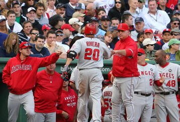 BOSTON - OCTOBER 11:  Juan Rivera #20 of the Los Angeles Angels of Anaheim is greeted at the dugout by manager Mike Scioscia and teammates after Rivera hit a two-run single in the eighth inning against the Boston Red Sox in Game Three of the ALDS during the 2009 MLB Playoffs at Fenway Park on October 11, 2009 in Boston,  Massachusetts. (Photo by Jim Rogash/Getty Images)