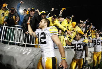 STATE COLLEGE, PA - SEPTEMBER 26:  Ricky Stanzi #12 of the Iowa Hawkeyes along with Adam Robinson #32 and Brett Morse #36 celebrate a 21-10 victory over the Penn State Nittnay Lions with Iowa fans on September 26, 2009 at Beaver Stadium in State College, Pennsylvania.  (Photo by Gregory Shamus/Getty Images)