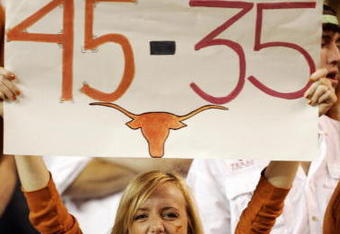 AUSTIN, TX - NOVEMBER 27:  A Texas Longhorn fan cheers on her team against the Texas A&M Aggies while holding a reminder of the Texas score against Oklahoma earlier in the season at Darrell K Royal-Texas Memorial Stadium November 27, 2008 in Austin, Texas.  (Photo by Brian Bahr/Getty Images)