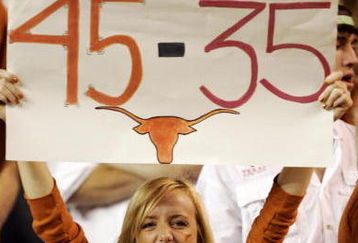 AUSTIN, TX - NOVEMBER 27:  A Texas Longhorn fan cheers on her team against the Texas A&M Aggies while holding a reminder of the Texas score against Oklahoma earlier in the season at Darrell K Royal-Texas Memorial Stadium November 27, 2008 in Austin, Texas.  (Photo by Brian Bahr/Getty Images)