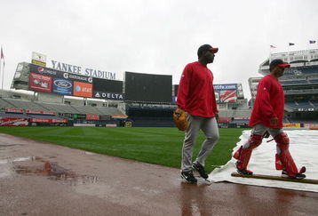 NEW YORK - OCTOBER 15: Darren Oliver #38 and coach Steve Soliz #61 of the Los Angeles Angels of Anaheim walk past the tarp covering the field during workouts on October 15, 2009 at Yankee Stadium in the Bronx borough of New York City.  (Photo by Jared Wickerham/Getty Images)