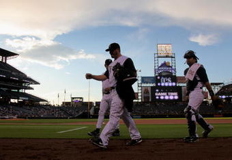 DENVER - SEPTEMBER 08:  Starting pitcher Jason Marquis #21 of the Colorado Rockies heads to the dugout before game time with catcher Yorvit Torrealba #8 and pitching coach Bob Apodaca #36 against the Cincinnati Reds at Coors Field on September 8, 2009 in Denver, Colorado.  (Photo by Doug Pensinger/Getty Images)