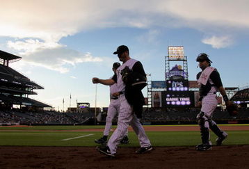 DENVER - SEPTEMBER 08:  Starting pitcher Jason Marquis #21 of the Colorado Rockies heads to the dugout before game time with catcher Yorvit Torrealba #8 and pitching coach Bob Apodaca #36 against the Cincinnati Reds at Coors Field on September 8, 2009 in Denver, Colorado.  (Photo by Doug Pensinger/Getty Images)