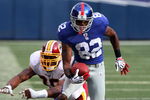 EAST RUTHERFORD, NJ - SEPTEMBER 13:  Mario Manningham #82 of the New York Giants eludes a tackle attempt from Andre Carter #99 of the Washington Redskins enroute to a touchdown on September 13, 2009 at Giants Stadium in East Rutherford, New Jersey.  (Photo by Jim McIsaac/Getty Images)