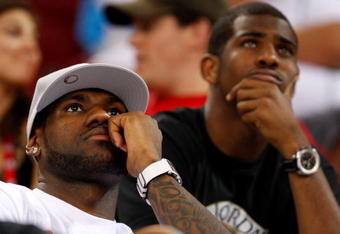 BEIJING - AUGUST 11:  (L-R) LeBron James and Chris Paul of the United States men's basketball team watch the United Staes women play against China during their women's basketball preliminary game on Day 3 of the Beijing 2008 Olympic Games at the Wukesong Indoor Stadium on August 11, 2008 in Beijing, China.  (Photo by Streeter Lecka/Getty Images)