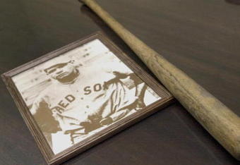 393274 05: A vintage photo and practice bat belonging to legendary ballplayer Herman 'Babe' Ruth sit on a table August 15, 2001 during a press conference to announce a public initiative to honor Ruth in Boston, MA. Ruth led the 1918 Red Sox to a World Series, but was traded the following year to the rival New York Yankees. Since then the Red Sox have gone 82 seasons without another championship. The drought has become known locally as the 'Curse of the Bambino.' The public initiative to honor Ruth is also designed to lift the curse. Red Sox management have never honored Ruth and will not participate in the September ceremony. (Photo by Darren McCollester/Getty Images)