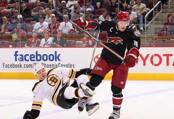 GLENDALE, AZ - OCTOBER 17:  Shane Doan #19 of the Phoenix Coyotes lays a body check onto Shawn Thornton #22 of the Boston Bruins during the NHL game at Jobing.com Arena on October 17, 2009 in Glendale, Arizona. The Coyotes defeated the Bruins 4-1.  (Photo by Christian Petersen/Getty Images)