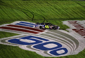 CONCORD, NC - OCTOBER 17:  Jimmie Johnson, driver of the #48 Lowe's Chevrolet, slides through the grass as he celebrates after winning the NASCAR Sprint Cup Series NASCAR Banking 500 at Lowe's Motor Speedway on October 17, 2009 in Concord, North Carolina.  (Photo by Streeter Lecka/Getty Images)