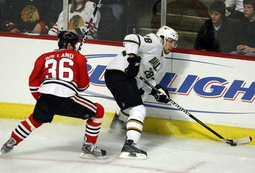 CHICAGO - FEBRUARY 14: Mark Fistric #28 of the Dallas Stars tries to control the puck along the boards under pressure from Dave Bolland #36 of the Chicago Blackhawks on February 14, 2009 at the United Center in Chicago, Illinois. The Blackhawks defeated the Stars 6-2. (Photo by Jonathan Daniel/Getty Images)