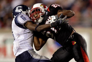 LOUISVILLE, KY - SEPTEMBER 26:  Victor Anderson #20 of the Louisville Cardinals is tackled by Jasper Howard #6 of the Connecticut Huskies during the Big East game against at Papa John's Stadium September 26, 2008 in Louisville, Kentucky.  (Photo by Andy Lyons/Getty Images)