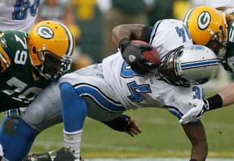 GREEN BAY, WI - OCTOBER 18:  Kevin Smith #34 of the Detroit Lions is tackled by Ryan Pickett #79 and A.J. Hawk #50 of the Green Bay Packers at Lambeau Field on October 18, 2009 in Green Bay, Wisconsin. The Packers defeated the Lions 26-0. (Photo by Jonathan Daniel/Getty Images)