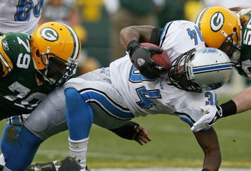 GREEN BAY, WI - OCTOBER 18:  Kevin Smith #34 of the Detroit Lions is tackled by Ryan Pickett #79 and A.J. Hawk #50 of the Green Bay Packers at Lambeau Field on October 18, 2009 in Green Bay, Wisconsin. The Packers defeated the Lions 26-0. (Photo by Jonathan Daniel/Getty Images)