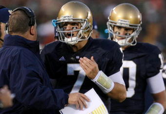 SOUTH BEND, IN - OCTOBER 17: Head coach Charlie Weis of the Notre Dame Fighting Irish speaks to quarterback Jimmy Clausen #7 during the fourth quarter against the USC Trojans at Notre Dame Stadium on October 17, 2009 in South Bend, Indiana. USC won the game 34-27. (Photo by Jonathan Daniel/Getty Images)