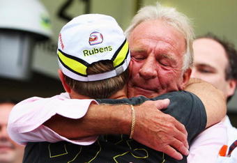 SAO PAULO, BRAZIL - OCTOBER 18:  Rubens Barrichello (L) of Brazil and Brawn GP is embraced by Jenson Buttons father John Button (R) after his son clinched the F1 World Drivers Championship during the Brazilian Formula One Grand Prix at the Interlagos Circuit on October 18, 2009 in Sao Paulo, Brazil.  (Photo by Mark Thompson/Getty Images)