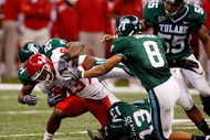 NEW ORLEANS - OCTOBER 17: Patrick Edwards #83 of the Houston Cougars is tackled by Phillip Davis #13 and Chinonso Echebelem #24 of the Tulane Green Wave at the Louisiana Superdome on October 17, 2009 in New Orleans, Louisiana. The Cougars defeated the Green Wave 44-16. (Photo by Chris Graythen/Getty Images)