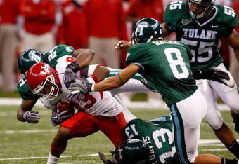 NEW ORLEANS - OCTOBER 17:  Patrick Edwards #83 of the Houston Cougars is tackled by Phillip Davis #13 and Chinonso Echebelem #24 of the Tulane Green Wave at the Louisiana Superdome on October 17, 2009 in New Orleans, Louisiana. The Cougars defeated the Green Wave 44-16.  (Photo by Chris Graythen/Getty Images)