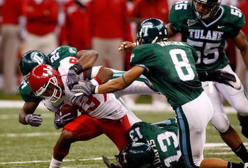 NEW ORLEANS - OCTOBER 17:  Patrick Edwards #83 of the Houston Cougars is tackled by Phillip Davis #13 and Chinonso Echebelem #24 of the Tulane Green Wave at the Louisiana Superdome on October 17, 2009 in New Orleans, Louisiana. The Cougars defeated the Green Wave 44-16.  (Photo by Chris Graythen/Getty Images)