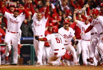 PHILADELPHIA - OCTOBER 19:  Carlos Ruiz #51 of the Philadelphia Phillies celebrates with his teammates as he slides safely into home as he scores the winning run on a walkoff 2-run double by Jimmy Rollins of the Los Angeles Dodgers in Game Four of the NLCS during the 2009 MLB Playoffs at Citizens Bank Park on October 19, 2009 in Philadelphia, Pennsylvania. The Phillies won 5-4.  (Photo by Chris McGrath/Getty Images)
