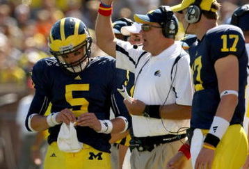 ANN ARBOR, MI - SEPTEMBER 19: Head coach Rich Rodriguez of the Michigan Wolverines is flanked by quarterbacks Tate Forcier #5 and David Cone #17 as he signals during the game with the Eastern Michigan Eagles at Michigan Stadium on September 19, 2009 in Ann Arbor, Michigan.  Michigan won 45-17.  (Photo by Stephen Dunn/Getty Images)