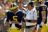 ANN ARBOR, MI - SEPTEMBER 19: Head coach Rich Rodriguez of the Michigan Wolverines is flanked by quarterbacks Tate Forcier #5 and David Cone #17 as he signals during the game with the Eastern Michigan Eagles at Michigan Stadium on September 19, 2009 in Ann Arbor, Michigan.  Michigan won 45-17.  (Photo by Stephen Dunn/Getty Images)