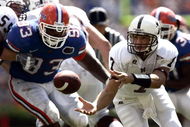 GAINESVILLE, FL - OCTOBER 8:  Quarterback Michael Henig #7 of Mississippi State hands off with defensive linemen Steven Harris #93 of the University of Florida in pursuit on October 8, 2005 at Ben Hill Griffin Stadium in Gainesville, Florida.  (Photo by Eliot J. Schechter/Getty Images)