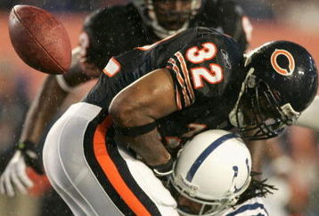 MIAMI GARDENS, FL - FEBRUARY 04:  Cedric Benson #32 of the Chicago Bears fumbles the ball after being tackled by Bob Sanders #21 of the Indianapolis Colts in the first quarter of Super Bowl XLI on February 4, 2007 at Dolphin Stadium in Miami Gardens, Florida.  (Photo by Donald Miralle/Getty Images)