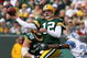 GREEN BAY, WI - OCTOBER 18: Aaron Rodgers #12 of the Green Bay Packers leaps to throw a pass under pressure from Kevin Hobbs #23 of the Detroit Lions at Lambeau Field on October 18, 2009 in Green Bay, Wisconsin. The Packers defeated the Lions 26-0. (Photo by Jonathan Daniel/Getty Images)