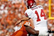 DALLAS - OCTOBER 17: Quarterback Sam Bradford #14 of the Oklahoma Sooners is tackled by Lamarr Houston #33 of the Texas Longhorns at Cotton Bowl on October 17, 2009 in Dallas, Texas. (Photo by Ronald Martinez/Getty Images)