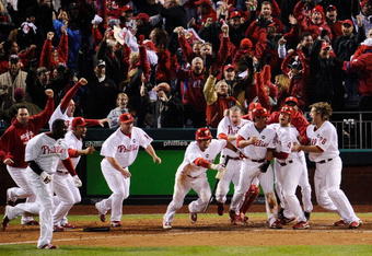 PHILADELPHIA - OCTOBER 19:  The Philadelphia Phillies celebrate after Carlos Ruiz scored the winning run on a walkoff 2-run double by Jimmy Rollins #11 in the bottom of the ninth inning to win 5-4 against the Los Angeles Dodgers in Game Four of the NLCS during the 2009 MLB Playoffs at Citizens Bank Park on October 19, 2009 in Philadelphia, Pennsylvania.  (Photo by Jeff Zelevansky/Getty Images)